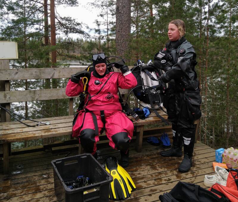 sukeltajat riisuvat varusteita